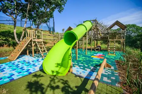Outdoor play area with a slide and climbing equipment at Simbithi